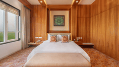 A close up view of a double bed with a painting hung above in the Suite - Shyama Sarovar Portico Orai