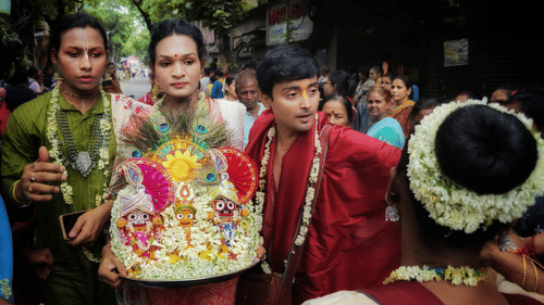 People holding idols of god showered by flowers.