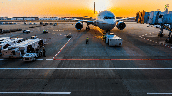 Airplane parked on airport runway during sunset near The Pride Premier Nagpur.