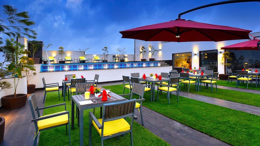 An image of a dining set up near our swimming pool seen during a cloudy evening - Golden Tulip, Agra