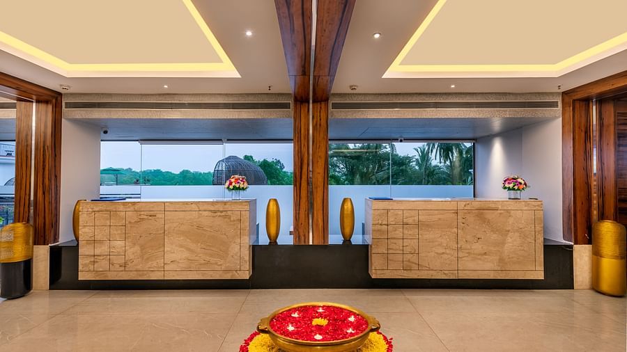 the reception area featuring two desk, ambient lighting, and an uril filled with rose petals and other flowers - Golden Tulip, Candolim, Goa