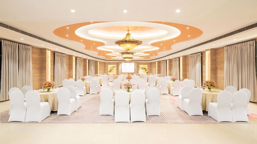 A wide angle view of a spacious event venue with a high ceiling and elegant decor, perfect for hosting weddings or corporate events