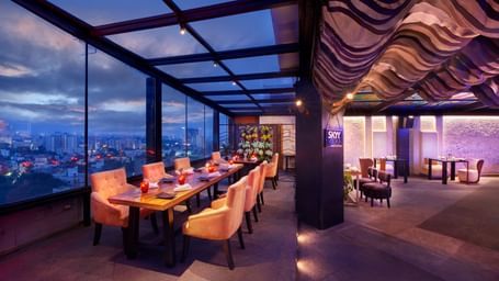 An image of a restaurant at the roof top featuring a seating area with tables and chairs at Accord Hotels and Resorts 