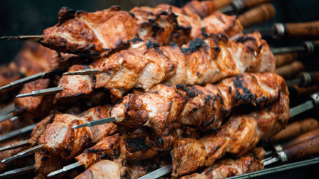 Stacked up skewers of grilled meat.