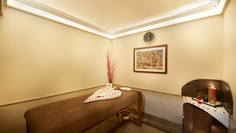 A spa room with a massage bed and a cabinet tool where spa products are kept at Accord Hotels and Resorts, one of the best 5 star luxury spa hotels in Chennai.