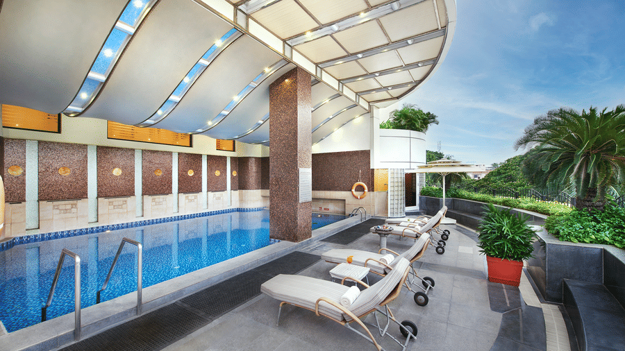 A swimming pool in a building with lounger beds near it at Accord Hotels and Resorts, one of the best 5 star hotels in T Nagar with a swimming pool.