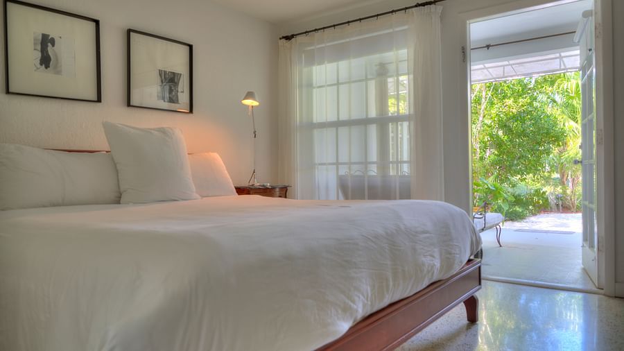 a spacious bedroom with a huge bed and a door leading to the garden at Casa Morada.