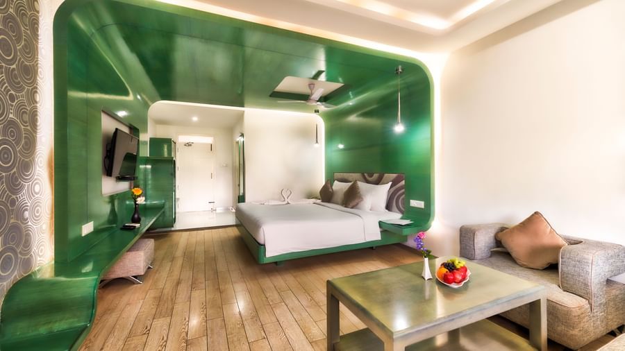 A room with king size bed, green wall panel and seating area at Grande Bay Resort & Spa.