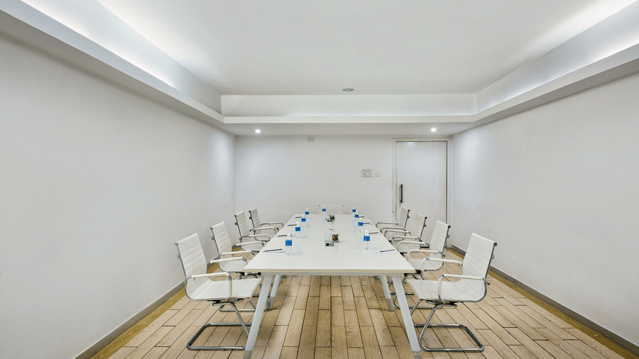 Conference room with long white table and white chairs at Grande Bay Resort & Spa, Mamallapuram.