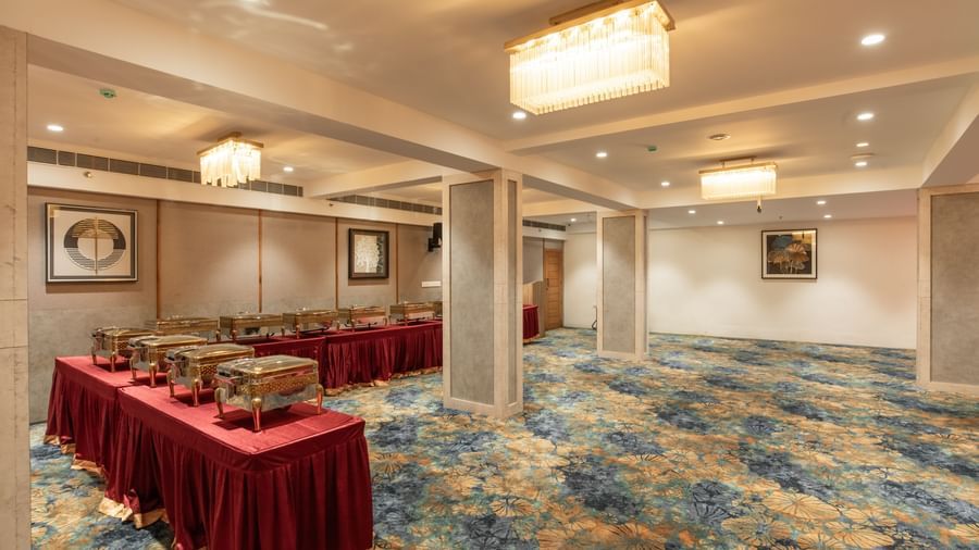 Banquet hall with round table setup and elegant chandeliers at Hotel Royal Regency Chennai