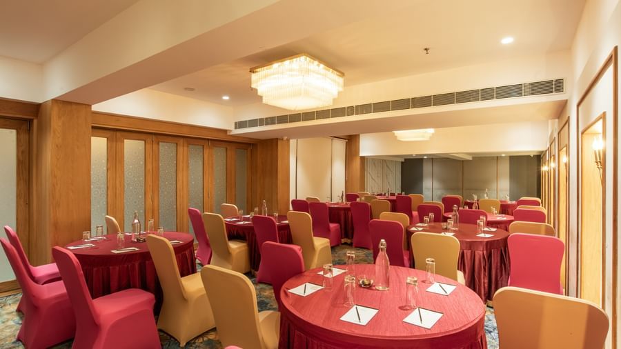 Spacious banquet hall with decorated tables and chairs at Hotel Royal Regency Chennai