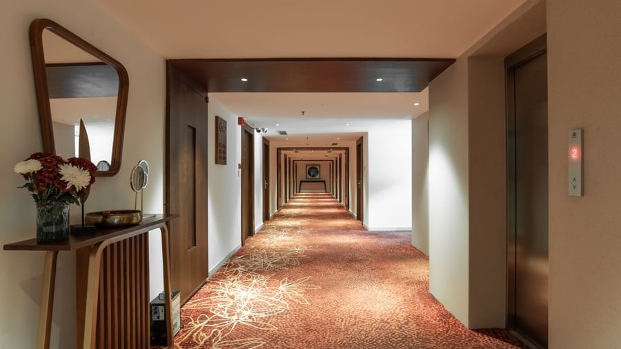 Elegant corridor with warm lighting and carpet flooring at Hotel Royal Regency Chennai
