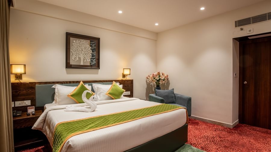 Bedroom featuring king size bed, bedside lamps, and warm lighting at Hotel Royal Regency Chennai