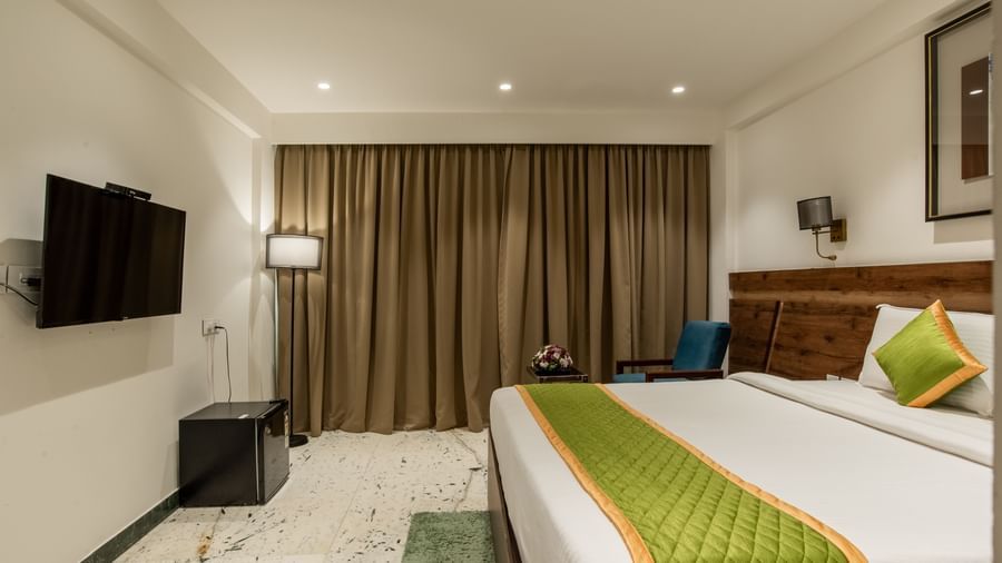 Guest room with king size bed, television, and warm lighting at Hotel Royal Regency Chennai