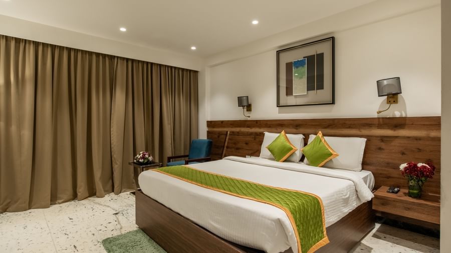 Bedroom with large curtains and elegant furnishings at Hotel Royal Regency Chennai