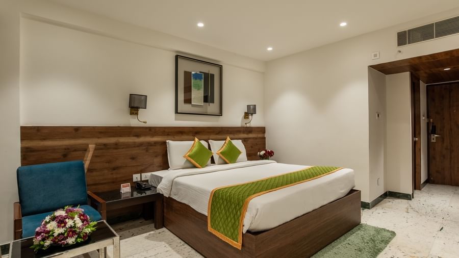 Spacious room with double bed, chairs, and bedside lamps at Hotel Royal Regency Chennai