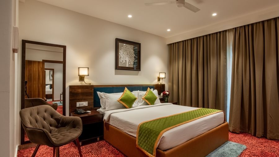 Spacious guest room with king size bed and seating area at Hotel Royal Regency Chennai