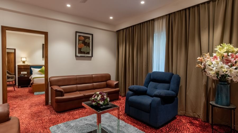 Living room with sofa set, armchair, and coffee table at Hotel Royal Regency Chennai