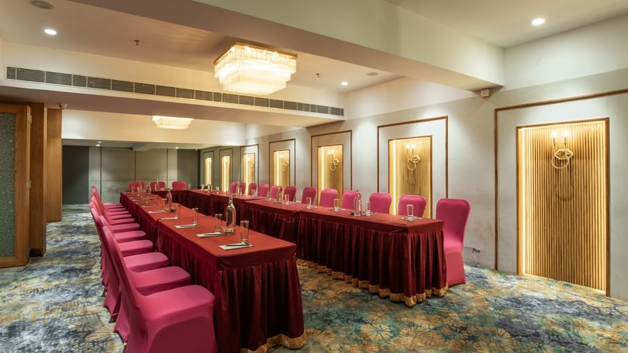 Event hall with seating arrangement and chandeliers at Hotel Royal Regency Chennai
