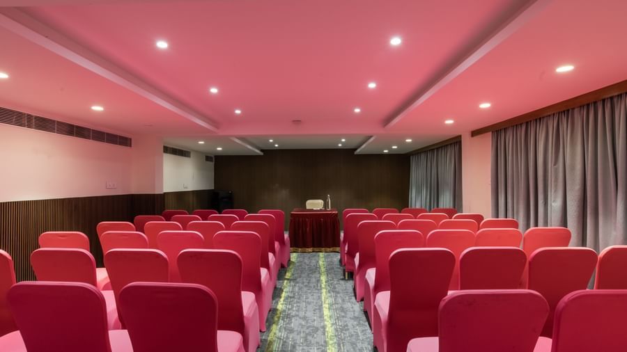 Banquet hall with theatre-style seating in red chairs at Hotel Royal Regency Chennai