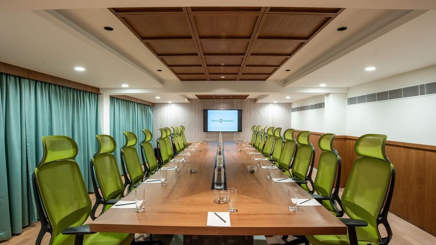 Professional meeting room with presentation screen and chairs at Hotel Royal Regency Chennai