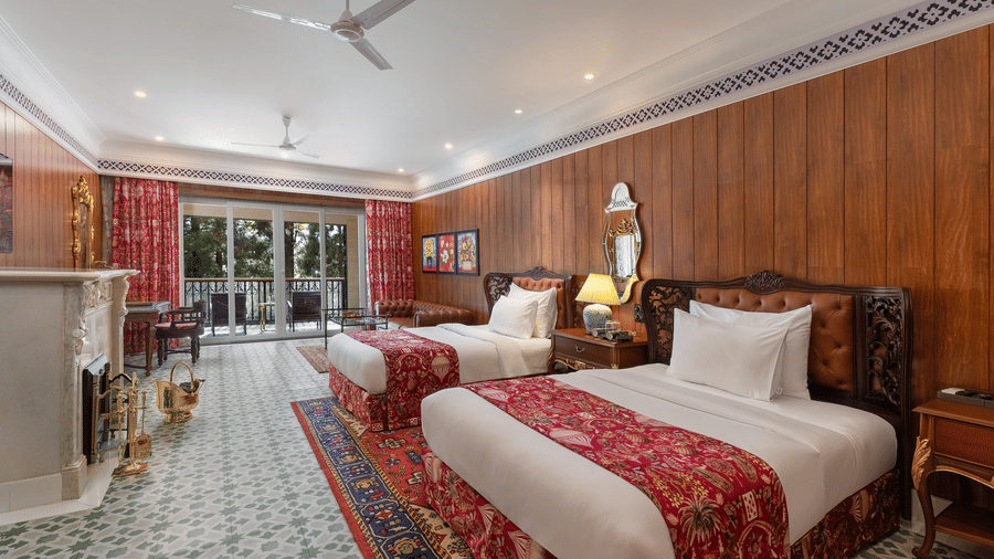 Spacious room with twin beds, fireplace, and patterned floor tiles at Mayfair Manor, Jungpana.