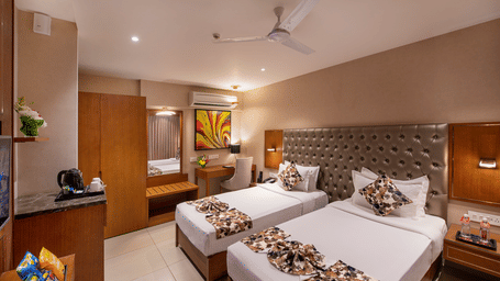 Twin bed room with bed post, dressing table with mirror, side table and AC