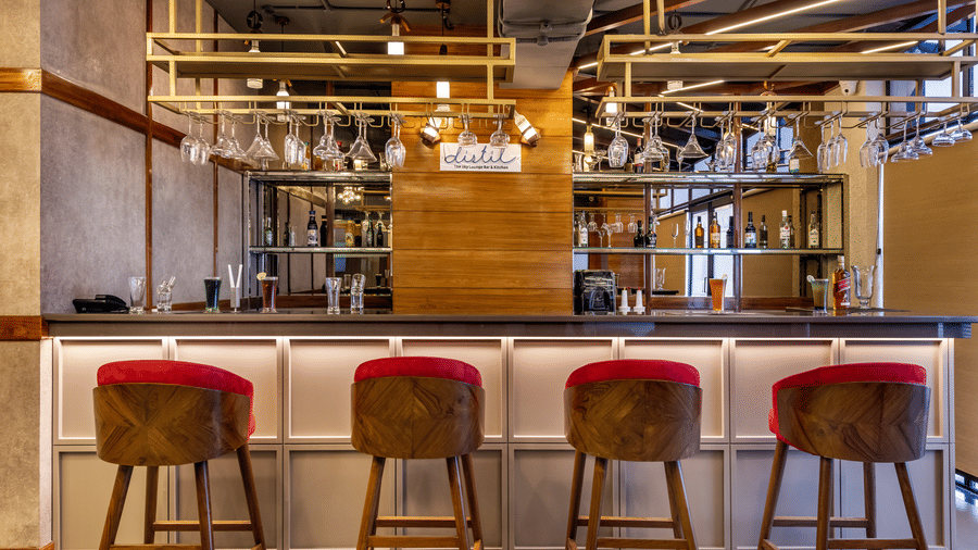 Distil bar setup with high stools, wood ceiling, and industrial lights.