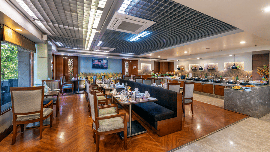 Spacious dining area with multiple tables and decorative ceiling at Lords Plaza Jaipur.