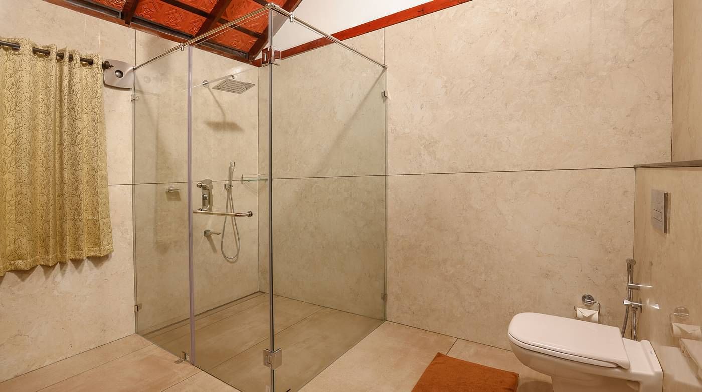 A glass cubicle and a wash basin in the bathroom | Vythiri Resort. Wayanad