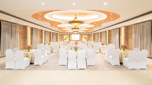 A wide angle view of a spacious event venue with a high ceiling and elegant decor, perfect for hosting weddings or corporate events