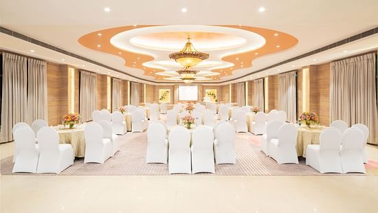 A wide angle view of a spacious event venue with a high ceiling and elegant decor, perfect for hosting weddings or corporate events