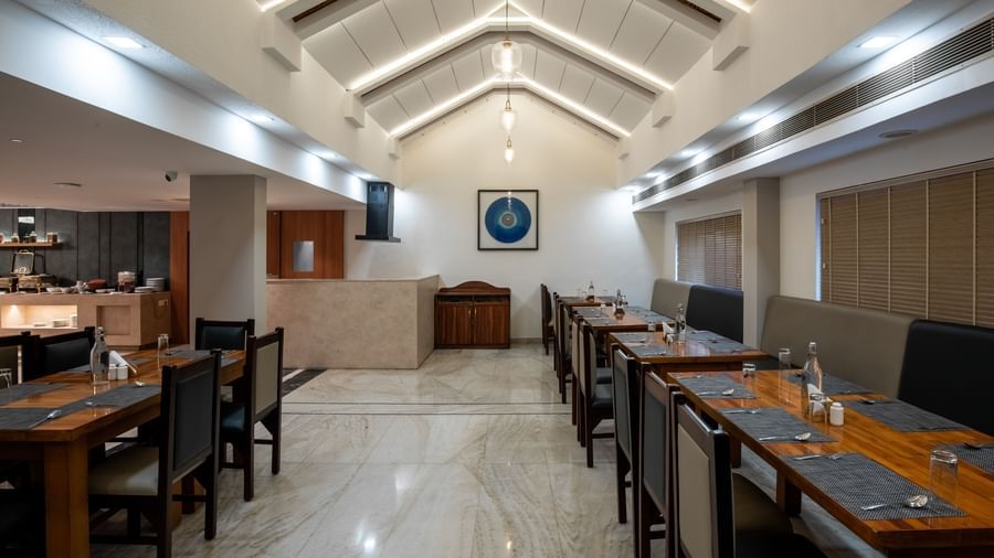 Well-lit restaurant with contemporary seating arrangement at Hotel Royal Regency Chennai