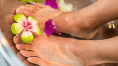 A beautiful feet on a bowl of rose water and flowers undergoing a spa treatment.