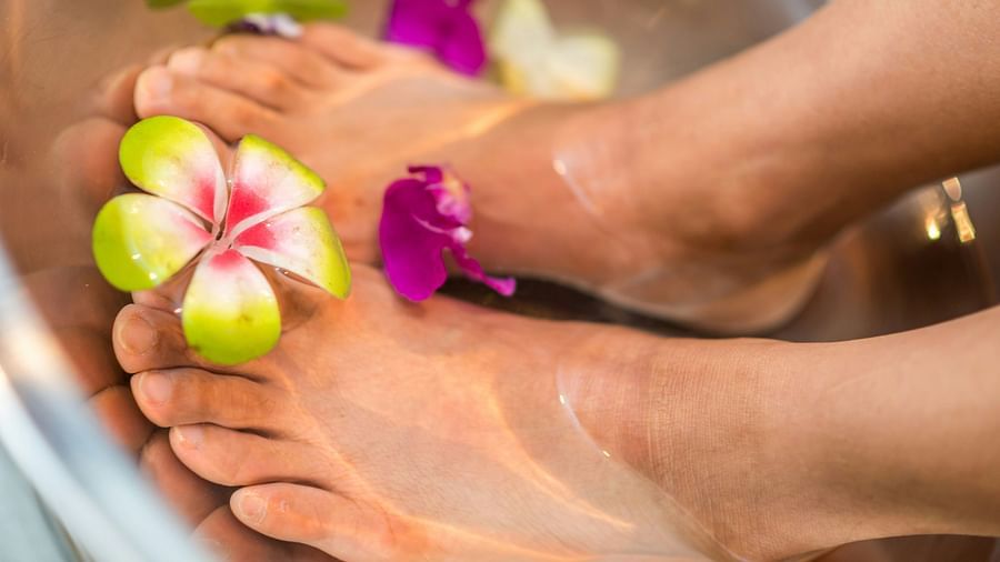 A beautiful feet on a bowl of rose water and flowers undergoing a spa treatment.