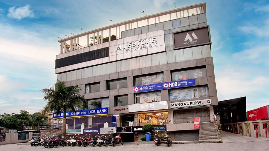 Exterior view of the multi-storey Voyage Milestone Hotel and Banquet Siliguri building with shops on the ground floor.