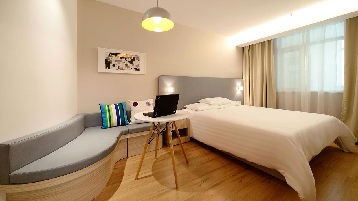 an image of a side view of a bedroom with a seating area