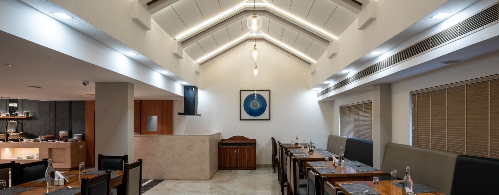 Well-lit restaurant with contemporary seating arrangement at Hotel Royal Regency Chennai