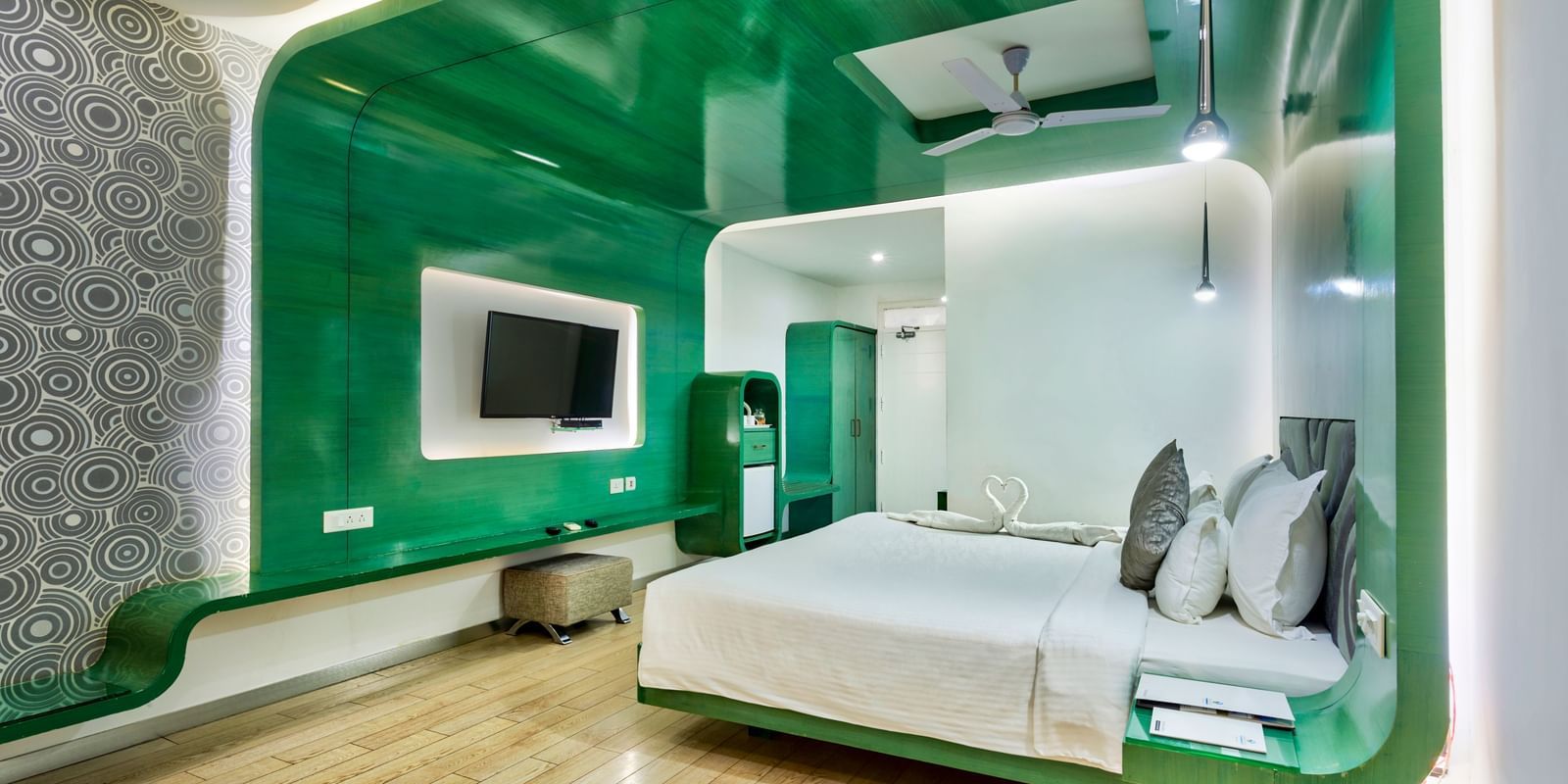 A room with a king bed, green wall panel and television at Grande Bay Resort & Spa.