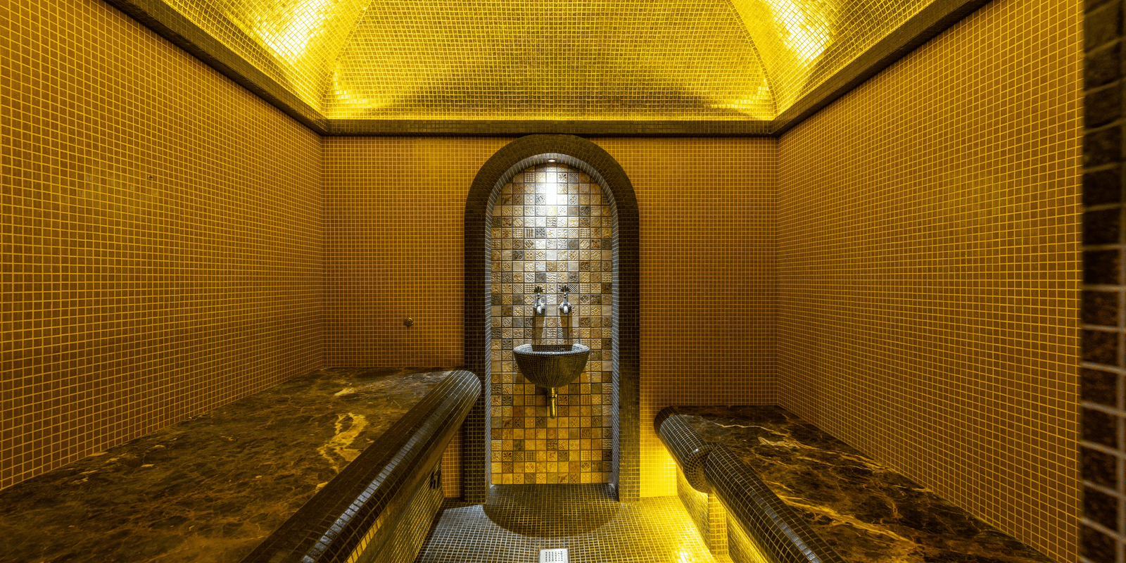 Close-up of a small, narrow chamber or shrine, illuminated entirely in bright golden light focusing on a central object.