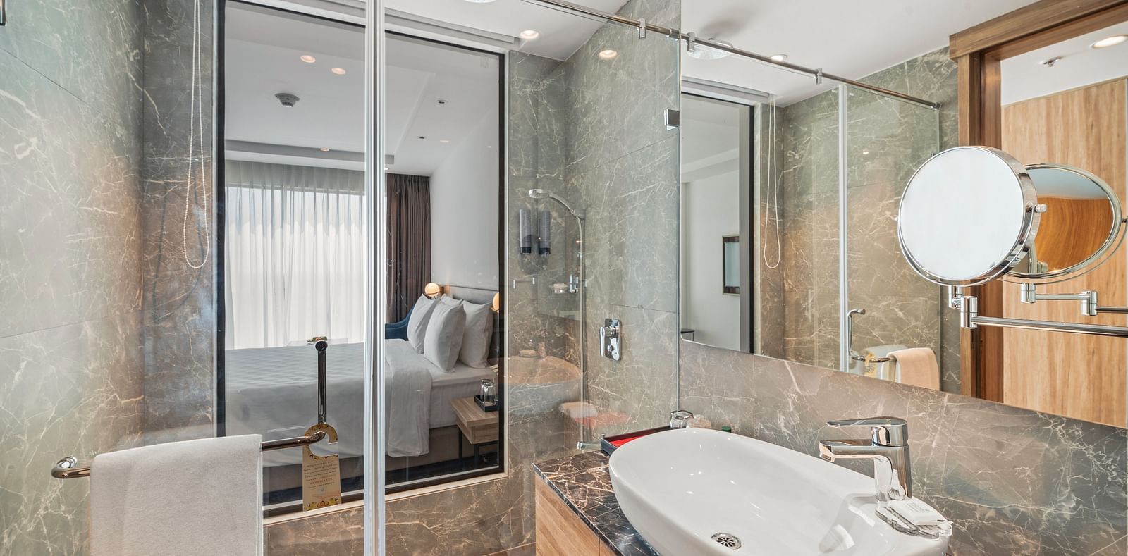 An image of a bathroom with a large sink, a shower cubicle and a shaving mirror - Grand Vijaywada by GRT Hotels