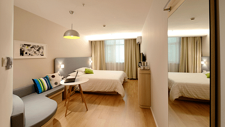 A image of a room with a comfortable bed, ambient lighting, cosy furniture and a television for entertainment