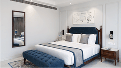 A picture of a large bed with a bed runner, a wall-mounted mirror, and a nightstand - MJ Sarovar Portico, Haridwar