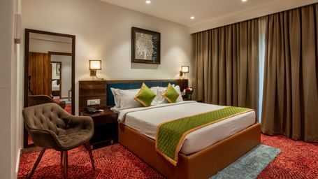 Spacious guest room with king size bed and seating area at Hotel Royal Regency Chennai