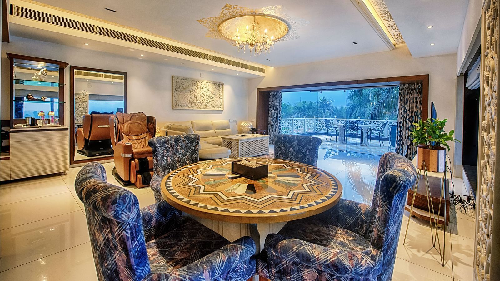 A well decorated room with a designer round table along with the chairs, shot while the room is filled with elegant lighting - Crescent Resorts