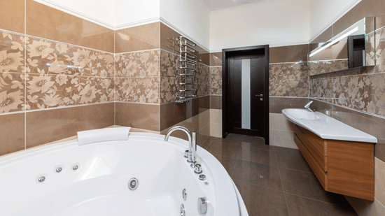 This modern bathroom features a sleek round Jacuzzi and a light-colored floating vanity with a wooden cabinet