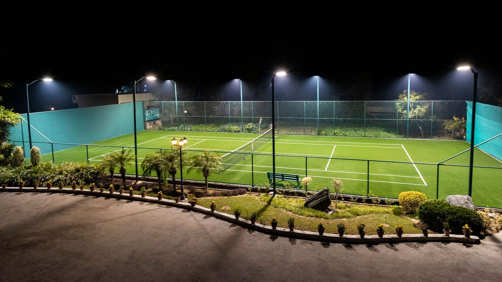 A view of a well-lit tennis court at BluSalzz Resort.