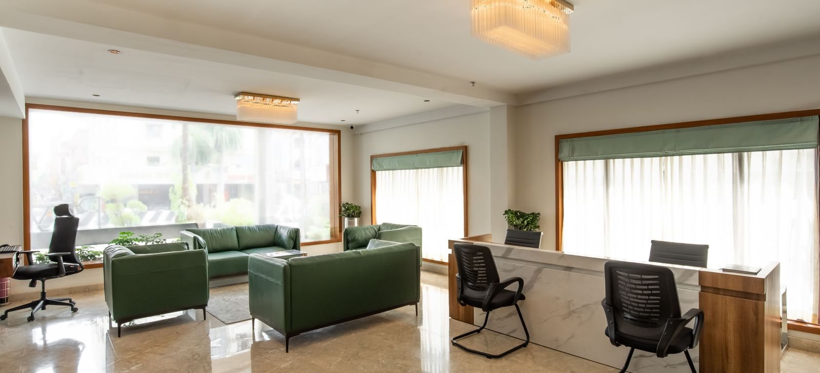 Spacious lounge area with sofas, chairs, and large windows at Hotel Royal Regency Chennai