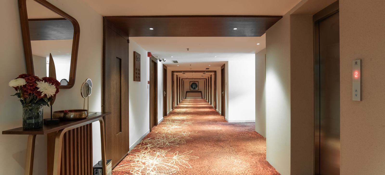 Elegant corridor with warm lighting and carpet flooring at Hotel Royal Regency Chennai