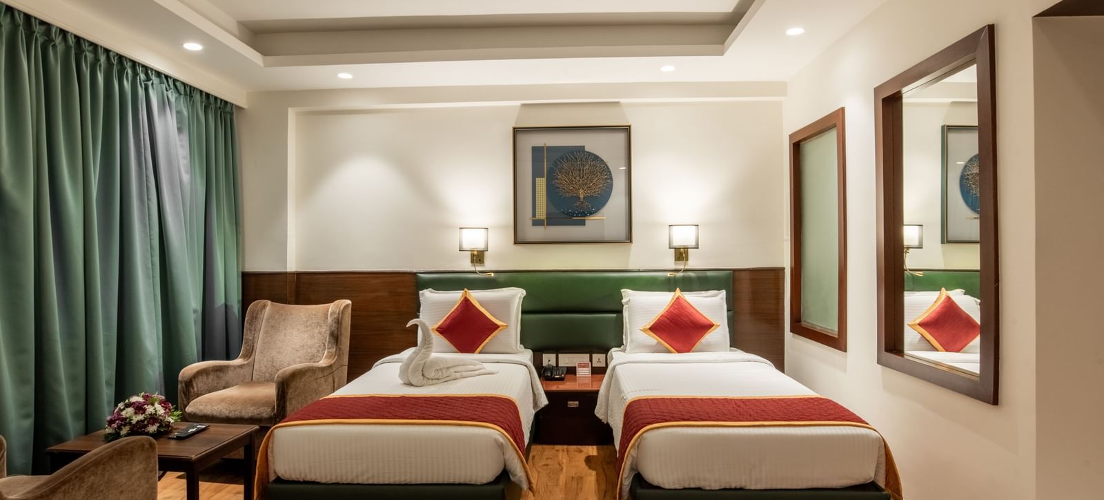 Room with twin beds, armchairs, and framed artwork at Hotel Royal Regency Chennai
